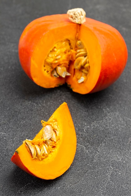 Orange pumpkin and pumpkin slice. Top view. Black background