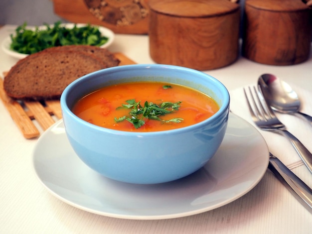 파란색 세라믹 그릇에 주황색 호박 수프