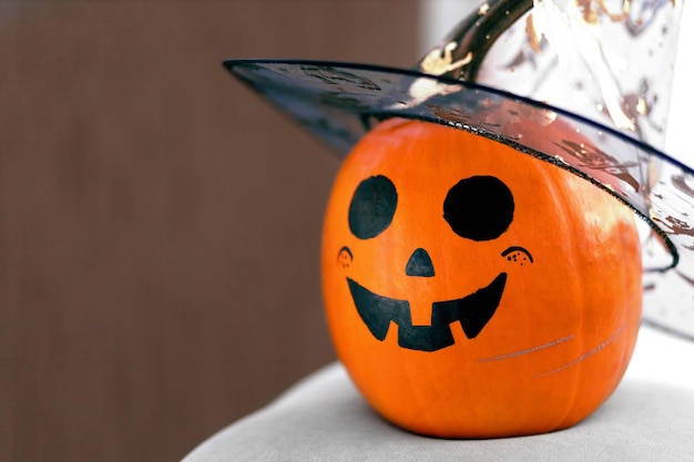 Orange pumpkin with a kind and smiling grimace close-up with space for text.