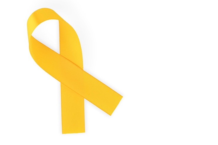 Photo orange ribbon, symbol of social awareness, isolated on white background, top view. world cancer day. copy space. high quality photo