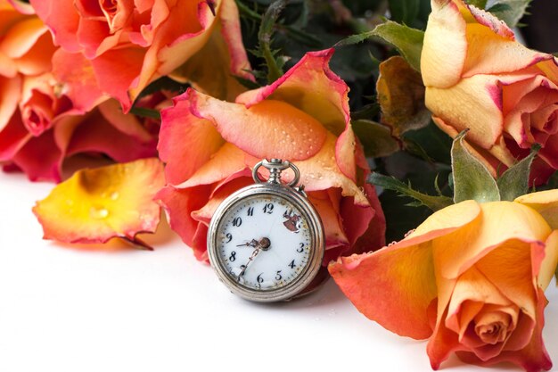 orange roses with vintage clock