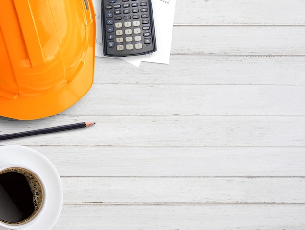 Orange safety helmet or hard hat on wood table background