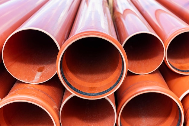 Orange sewer pipes at the construction site Preparation for the installation of an underground sewer system Wastewater disposal