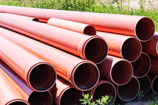 Orange sewer pipes at the construction site Preparation for the installation of an underground sewer system Wastewater disposal