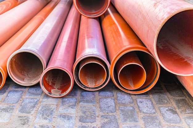 Orange sewer pipes lie on a construction site. preparation for earthworks for the installation of an underground pipeline