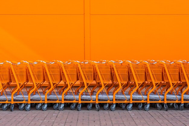 Orange shopping cart stacked by the entrance