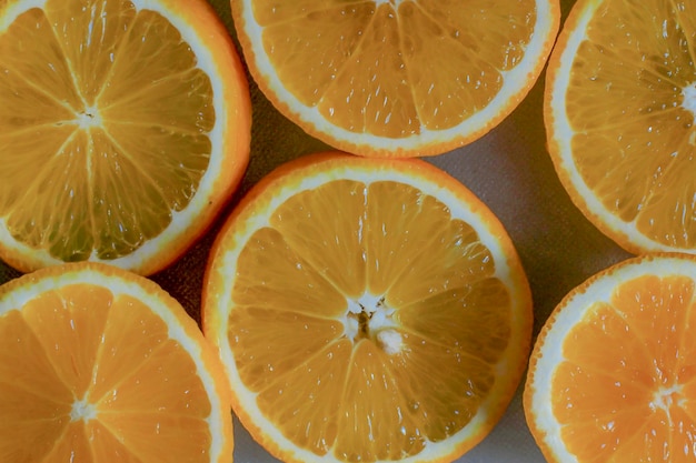 Долька апельсина. Фон из наполовину разрезанных апельсинов на оранжевом фоне