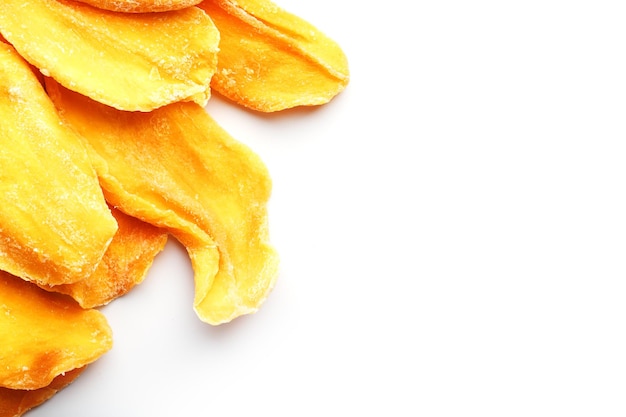 Оранжевые ломтики сушеного сахарного манго на белом фоне