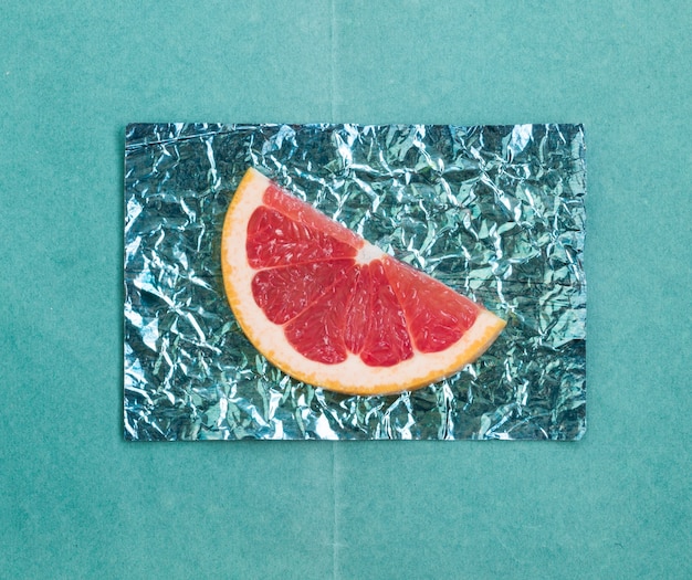 Orange and slices and grapefruit on stands made of colored foil