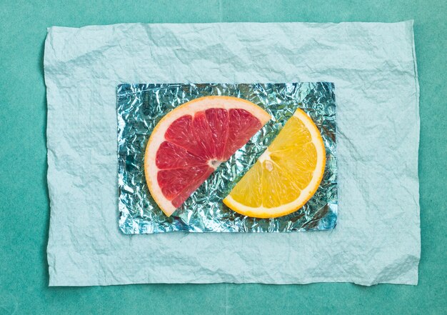 Orange and slices and grapefruit on stands made of colored foil