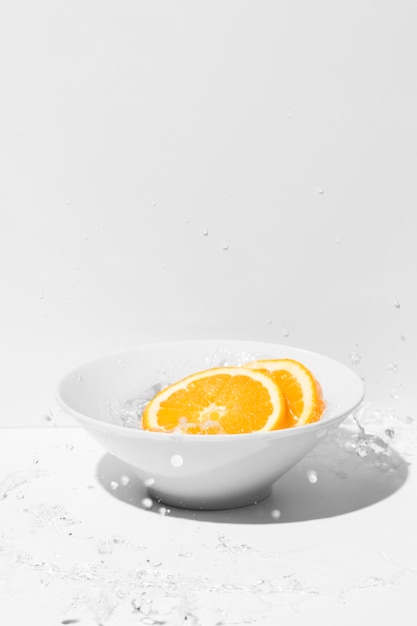 Orange slices with bowl and copy space