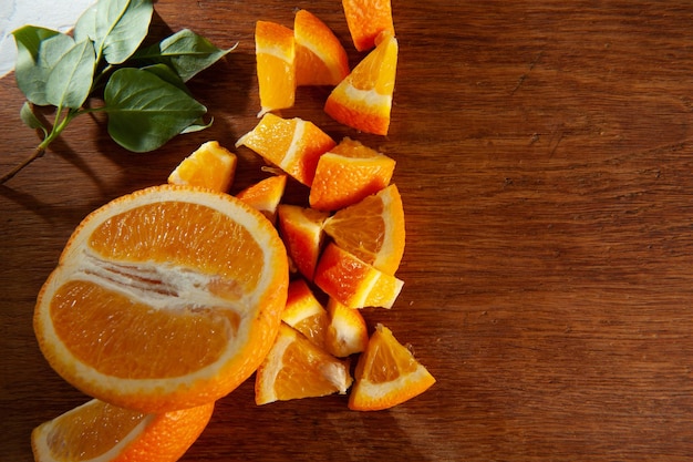 Orange slices on wooden board with green leaf