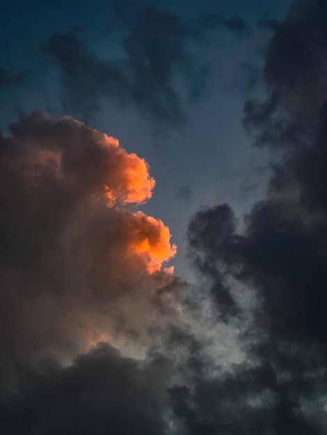 写真 暗い嵐の空の間の夕暮れの雲のオレンジ色のスライム