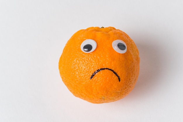 Orange smiley on white background Orange with eyes and sad smile Food with Funny Faces