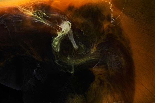 Orange smoke on black ink background, colorful fog, abstract swirling ocean sea, acrylic paint pigment underwater