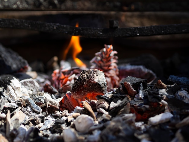 Foto carboni fumanti arancioni e fiamma bassa nel barbecue