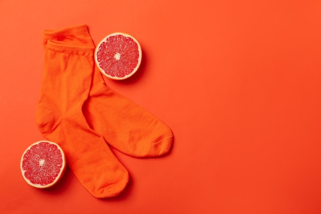 Orange socks and grapefruit on orange background