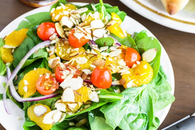 Orange spinach salad on the plate in Italian restaurant.