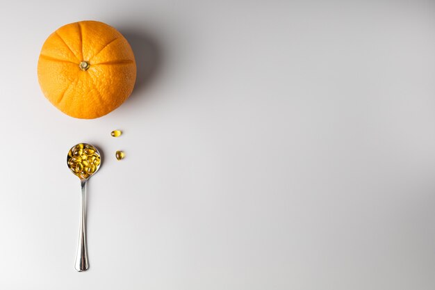 Апельсин и ложка с витамином С