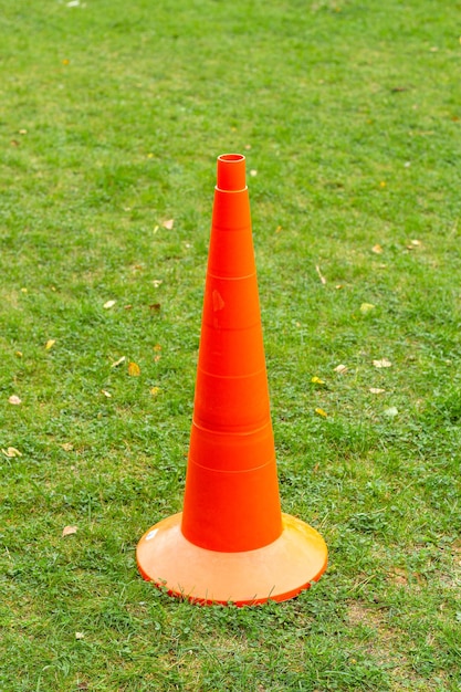 Orange sports equipment cone on a green lawn