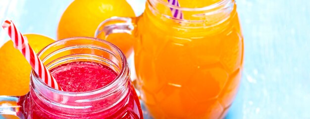 Photo orange and strawberry juice on blue wooden table