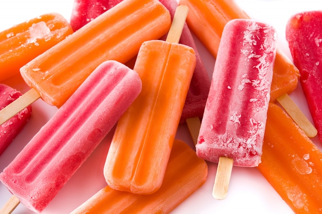 Orange and strawberry popsicles isolated on white