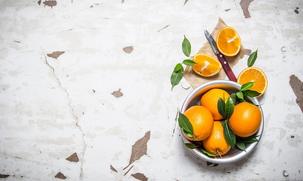 Orange style. Fresh oranges with leaves in a Cup .