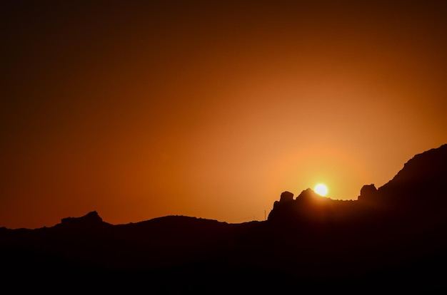 Orange Sun Setting Behind the Mountains