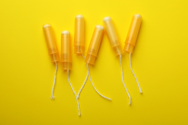 Orange tampons on yellow, top view