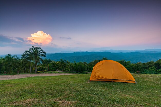 orange tent on the cliff in the evening.