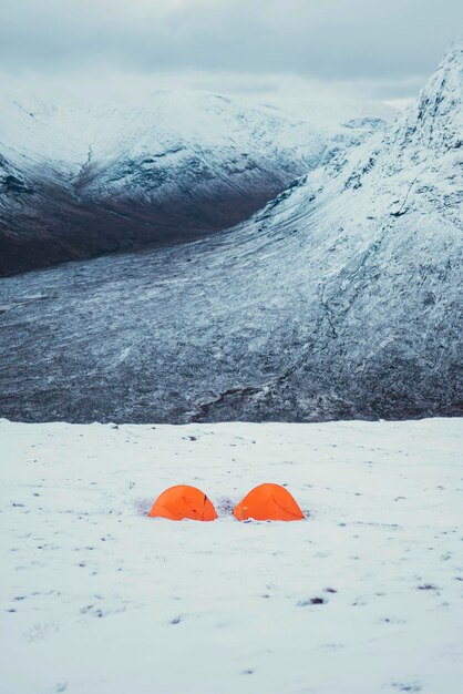 Orange tents at a snowy mountain