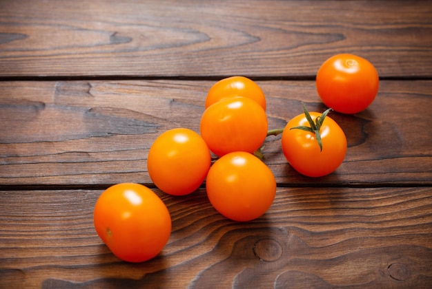 Pomodori arancioni su fondo di legno scuro