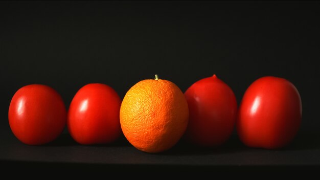 Orange and tomatoes in a row