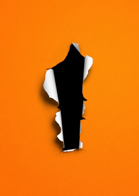 Orange torn paper with black hole