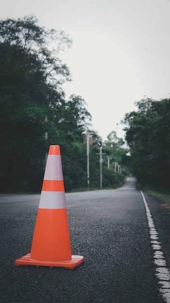 写真 オレンジ色のトラフィックコーンタイの田舎道で車に乗り込まないように警告するために使用されます。