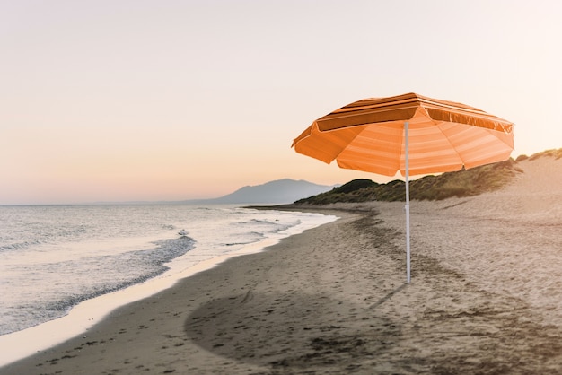 Foto ombrello arancione sul collage sulla spiaggia