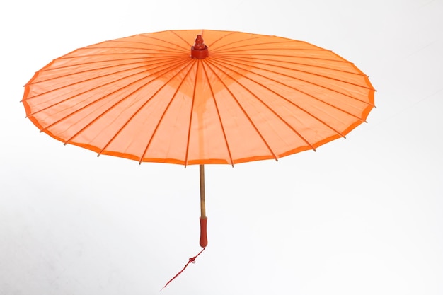 An orange umbrella with a red string on the end.