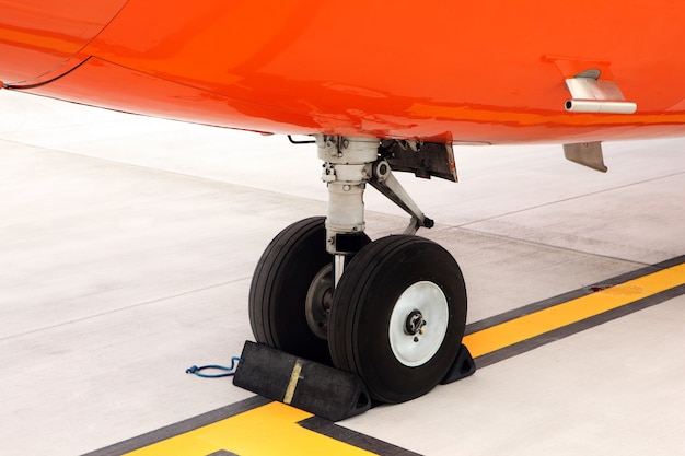 an orange undercarriage of a business jet standing on the apron