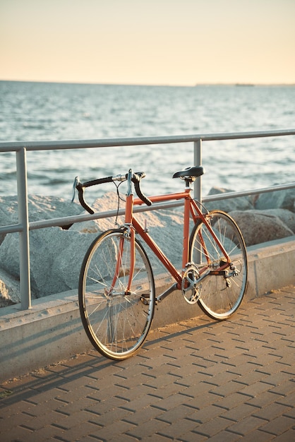 Orange vintage road bicycle closeup of a bike on the seaside\
during a summer evening old cycle restored