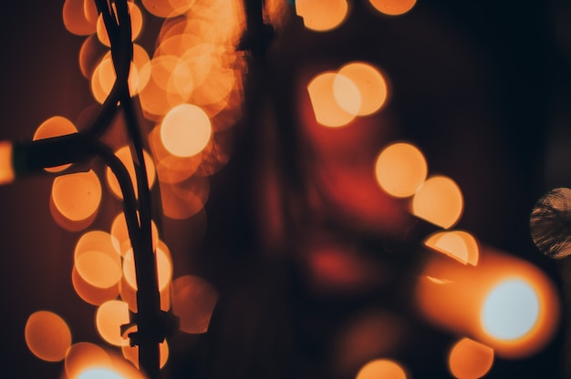 Orange warm bokeh from the LED garland on the facade of the building. Concept of festive Christmas bokeh and light. Template for design. Copy space.