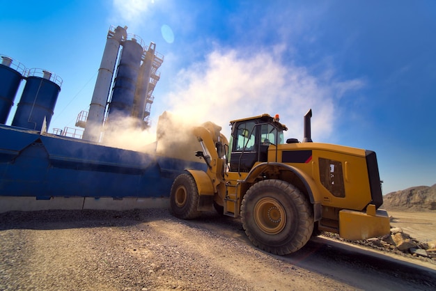 Orange wheel loader excavator in the background of a gravel storage in the open air Quarry and mining equipment