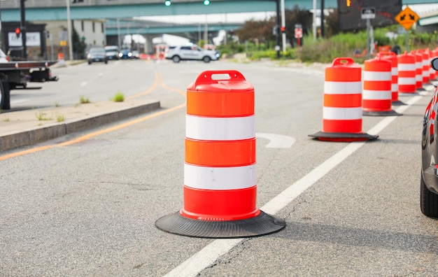 Orange and white construction barrels are on the road.