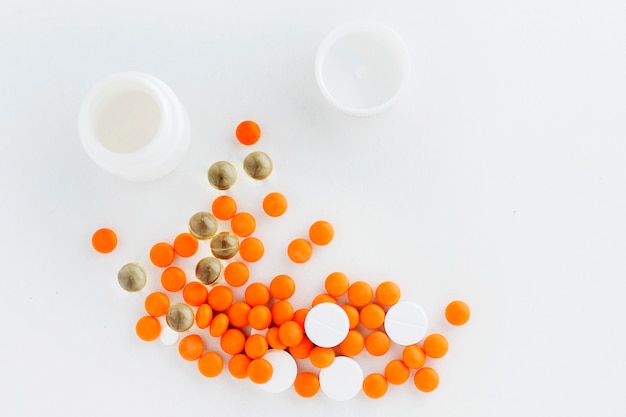 Orange and white pills on a white background