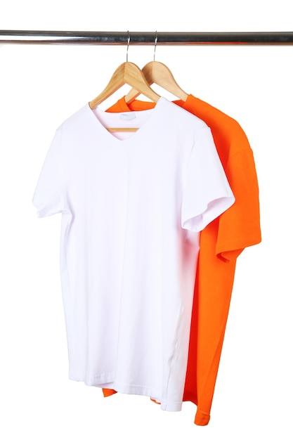 Orange and white tshirts on hanger on white background