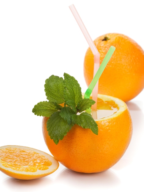 Orange with juice, two drinking straws and mint leaves