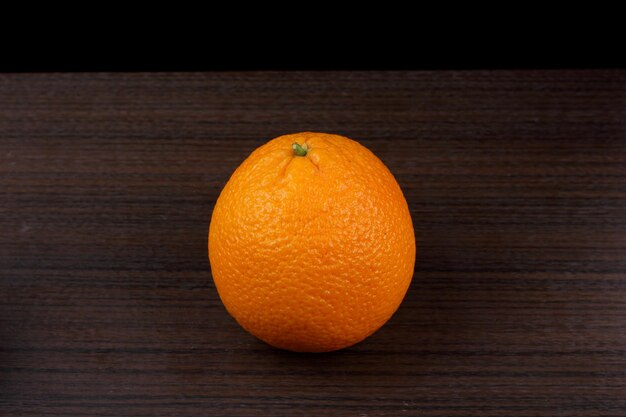 Orange on wooden background. Ripe oranges on dark background