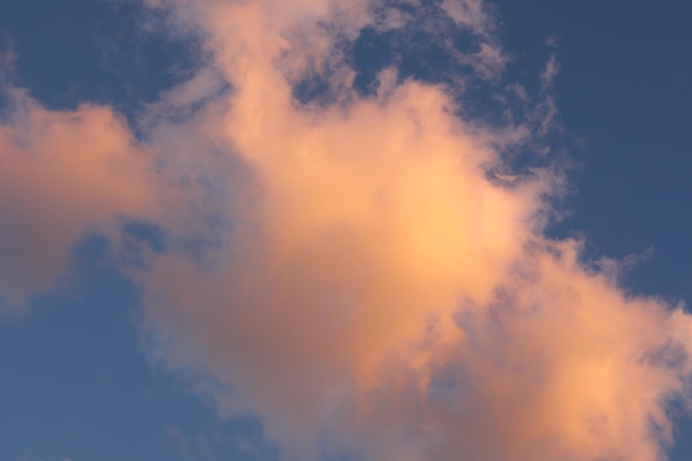 An orange and yellow cloud, illuminated at sunset