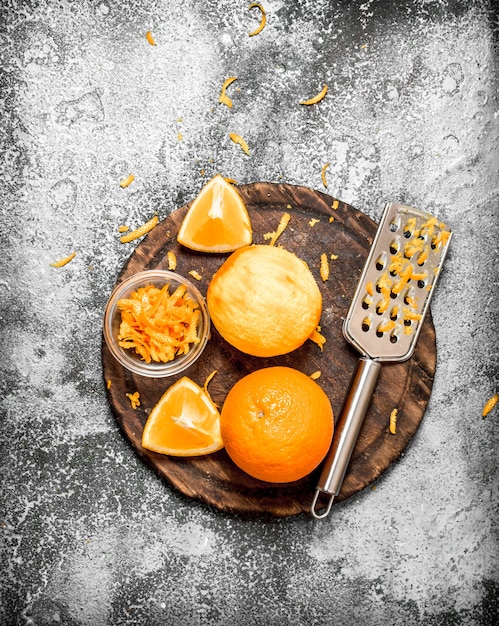 Orange zest with a grater . On rustic surface.