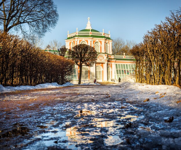 Оранжерея с отражением в растаявшем снегу в Кусково в Москве