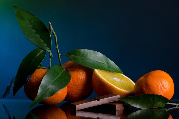 Photo oranges and chocolate on dark blue background